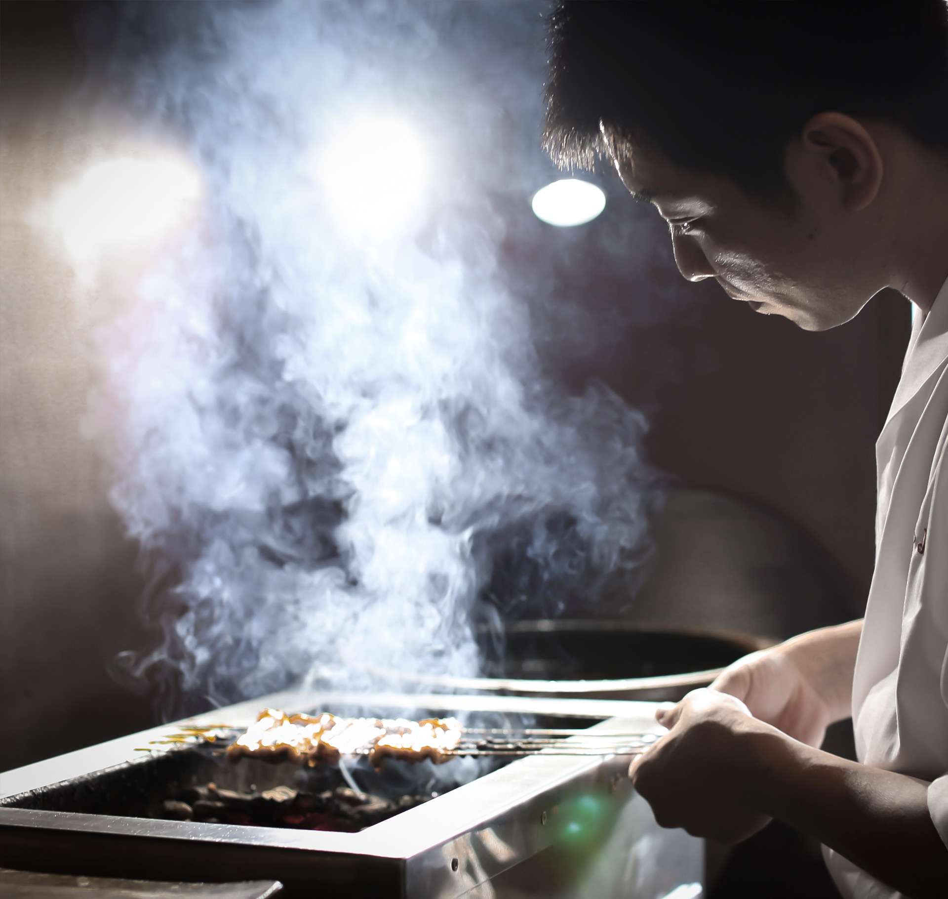 炭火で穴子を焼く職人